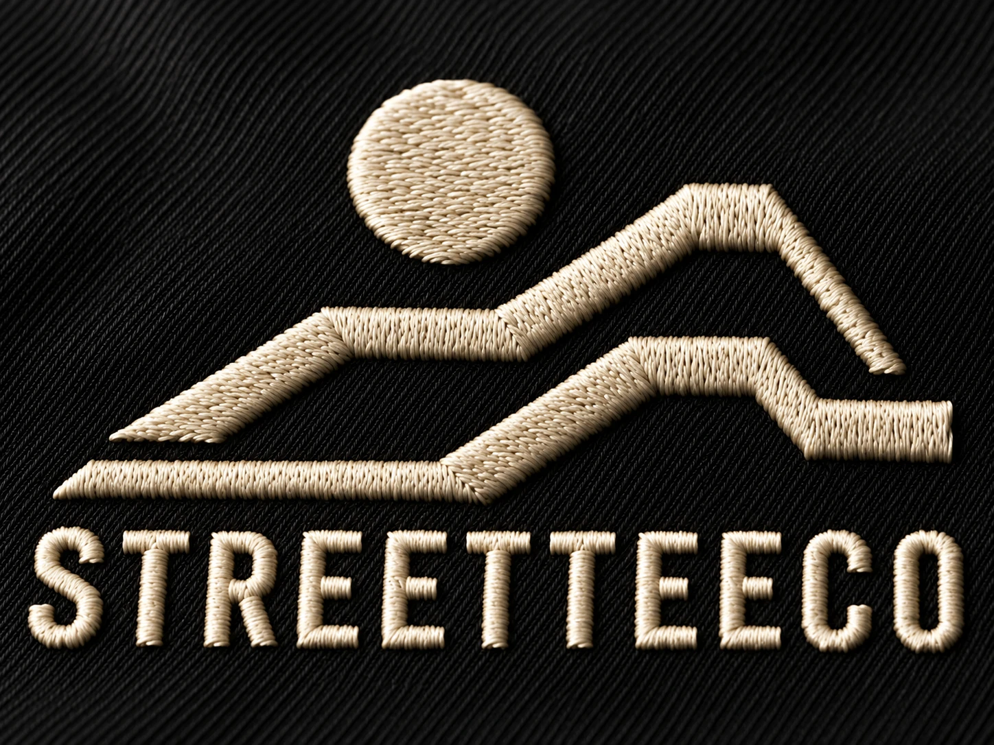 Original STREETTEECO landscape emblem and wordmark embroidered in ivory thread on black fabric