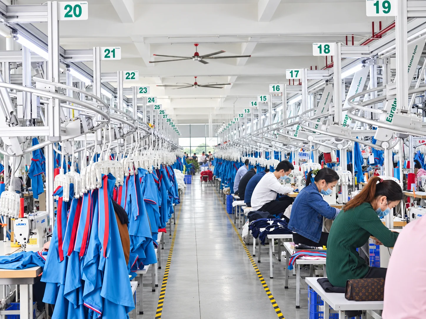 A wide view of the garment production floor and overhead hanger lines.